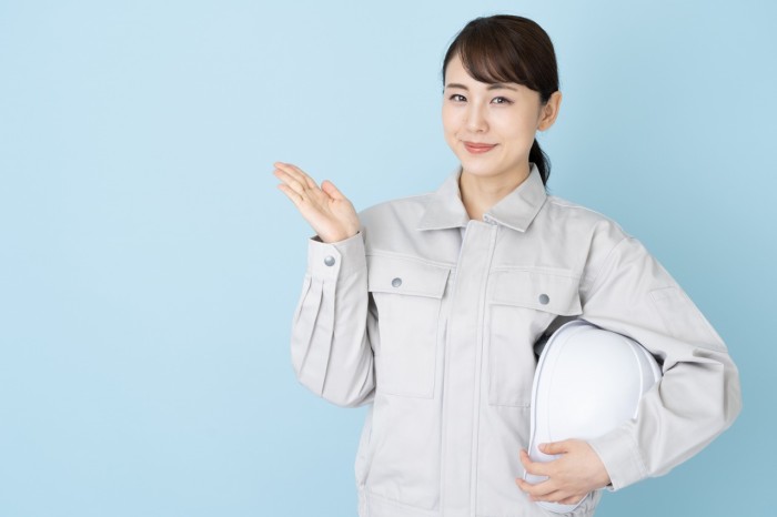 案内する作業着の女性